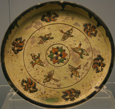 Multi-colored glazed porcelain plat with engraved flying bird and cloud design