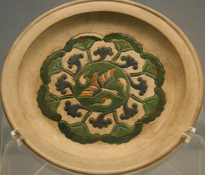 Multi-colored glazed porcelain plat with engraved flying bird and cloud design